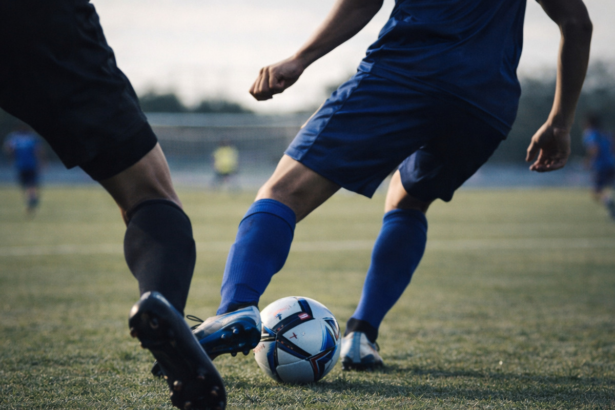 相手のプレッシャーを受けながら前を向いた瞬間の足元を捉えたサッカーの一場面